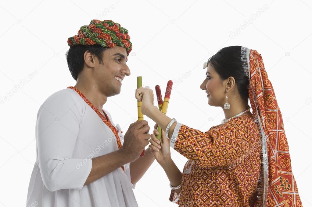 Couple performing Dandiya Raas at Navratri