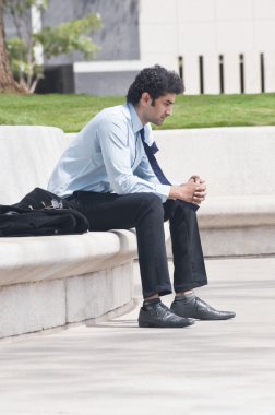 bir bahçede oturan işadamı