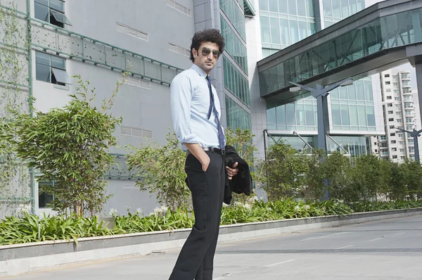 Businessman standing in front of an office building — Stock Photo, Image