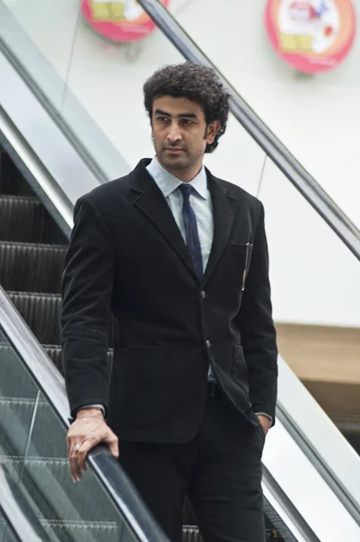 Businessman moving down on an escalator — Stock Photo, Image