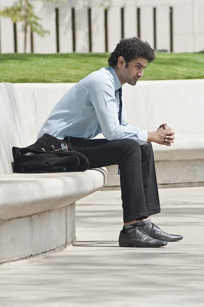 Businessman sitting in a garden — Stock Photo, Image