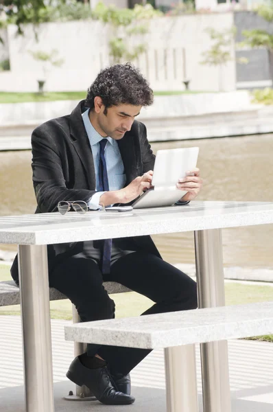 Empresario usando una tableta digital junto a la piscina — Foto de Stock