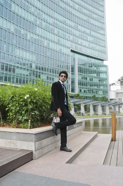 Businessman standing in front of an office building — Stock Photo, Image