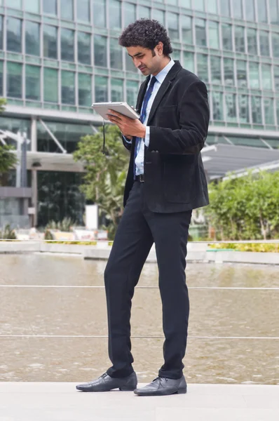 Empresario caminando en un jardín — Foto de Stock