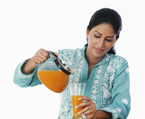 Γυναίκα ρίχνει χυμό σε ένα ποτήρι — Φωτογραφία Αρχείου