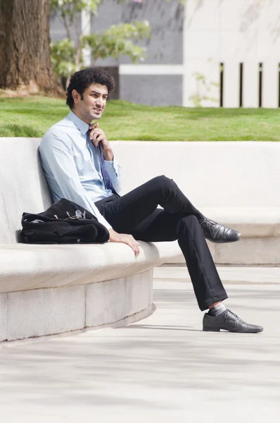 Businessman sitting in a garden — Stock Photo, Image