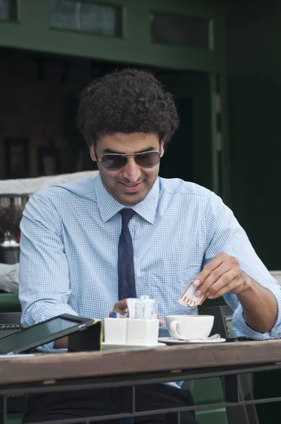 Uomo d'affari che versa zucchero nel caffè — Foto Stock