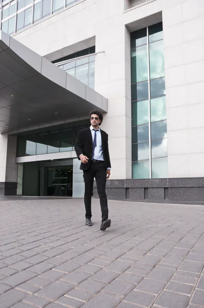 Empresario caminando frente a un edificio de oficinas — Foto de Stock