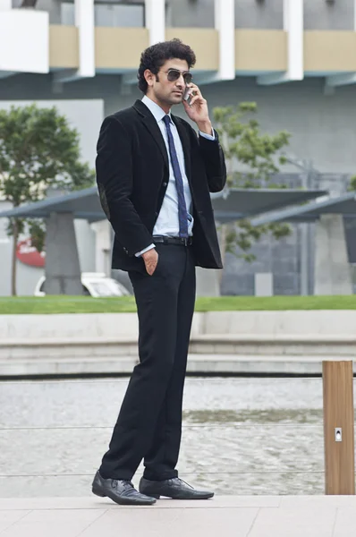 Empresario hablando en un teléfono móvil junto a la piscina —  Fotos de Stock