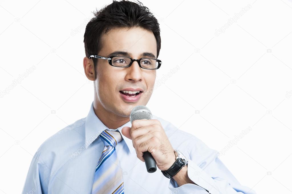 Businessman giving speech into a microphone
