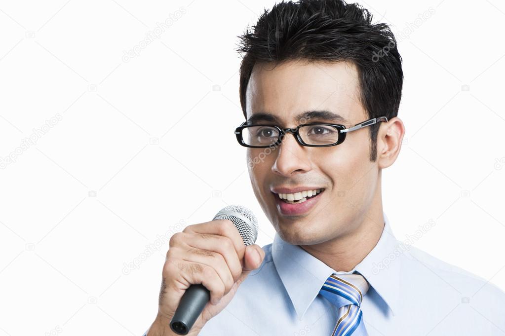 Businessman giving speech into a microphone