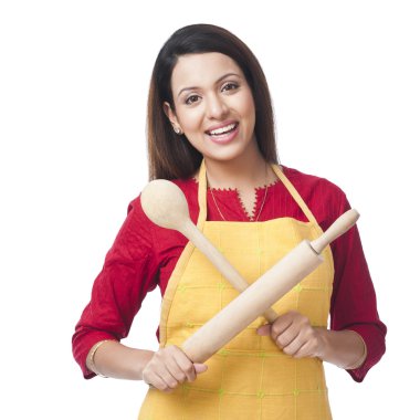 Woman holding a rolling pin and ladle clipart