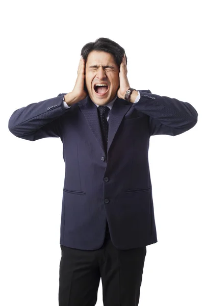 Businessman screaming with hands over his ears — Stock Photo, Image