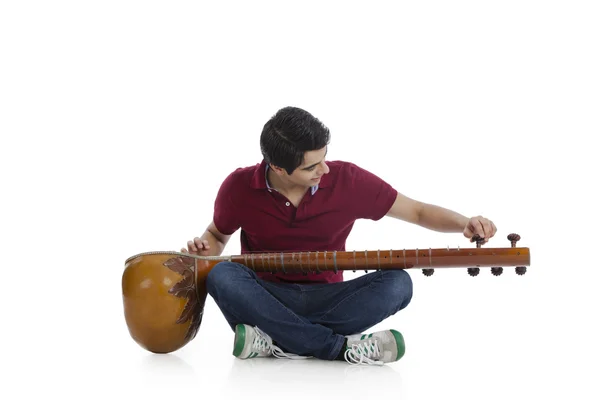 Hombre ajustando su sitar — Foto de Stock