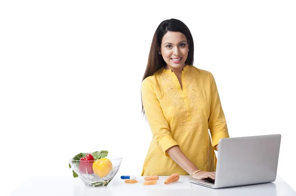 Mujer usando un portátil en una cocina —  Fotos de Stock