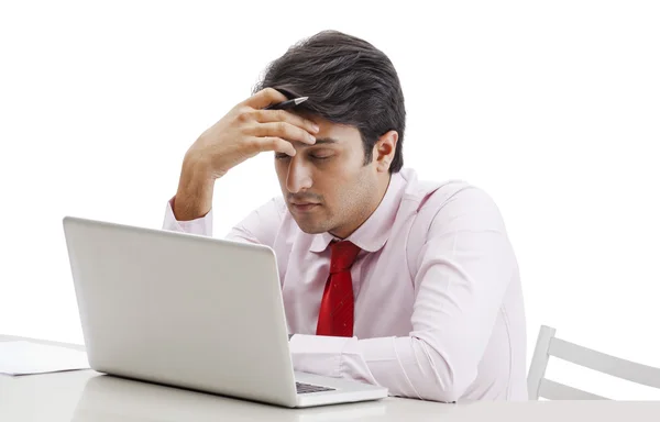 Businessman thinking in front of a laptop — Stock Photo, Image