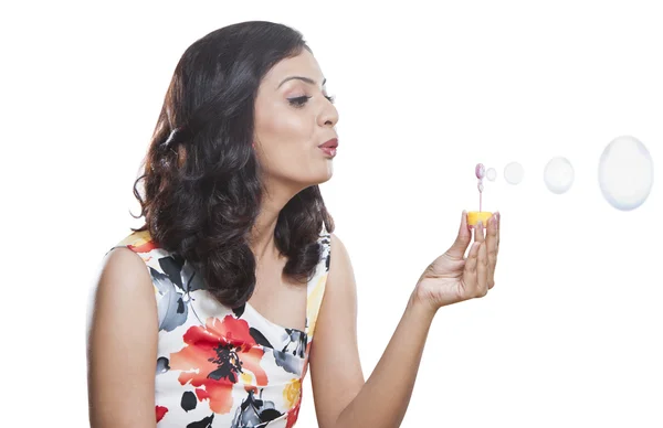 Woman blowing bubbles with a bubble wand — Stock Photo, Image