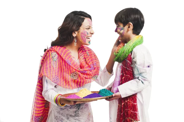 Mujer celebrando el festival Holi con su hijo — Foto de Stock
