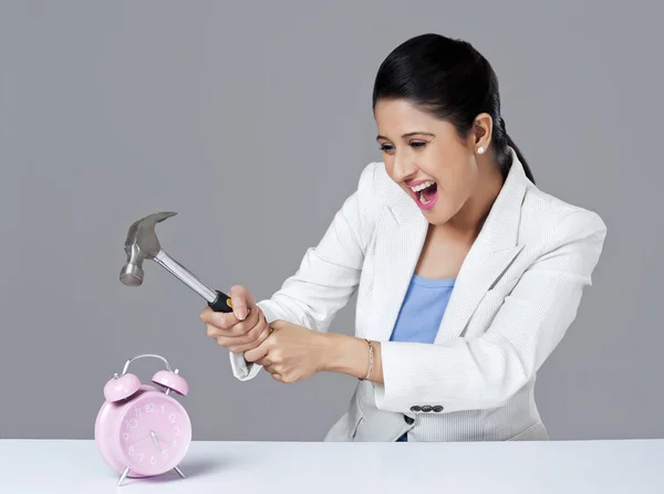 Businesswoman smashing alarm clock — Stock Photo, Image