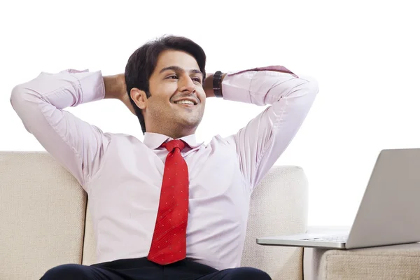 Businessman looking cheerful in front of a laptop — Stock Photo, Image