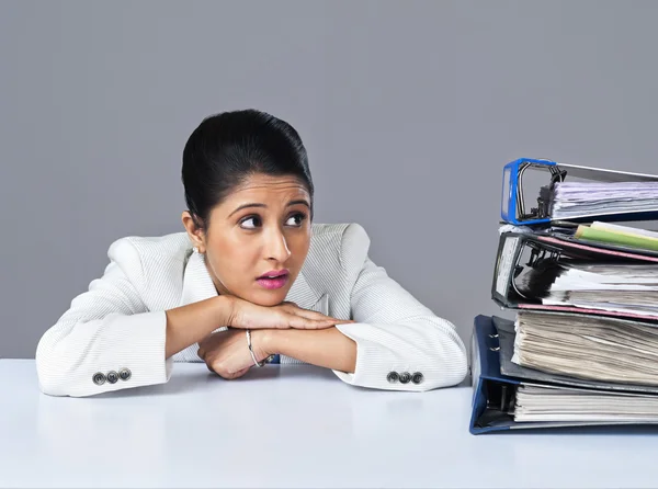 Affärskvinna tittar på högar av filer — Stockfoto