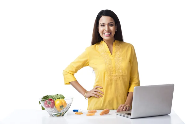 Woman using a laptop in a kitchen — Stock Photo, Image