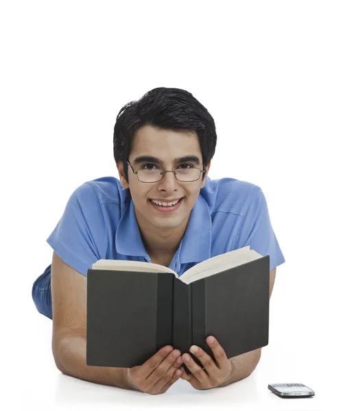 Man lying on the floor with a book — Stock Photo, Image