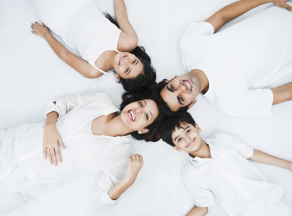 Liggend op het bed en gelukkige familie — Stockfoto