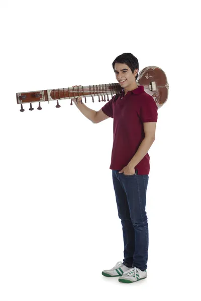 Man carrying a sitar on his shoulders — Stock Photo, Image