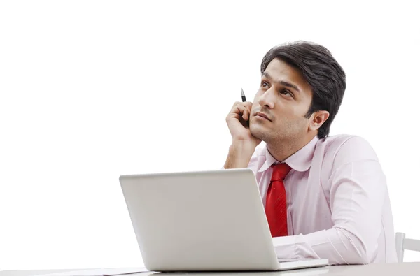 Zakenman denken voor een laptop — Stockfoto