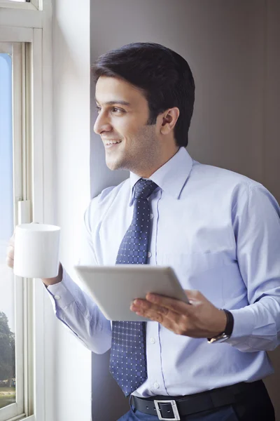 Empresário segurando uma xícara de café — Fotografia de Stock