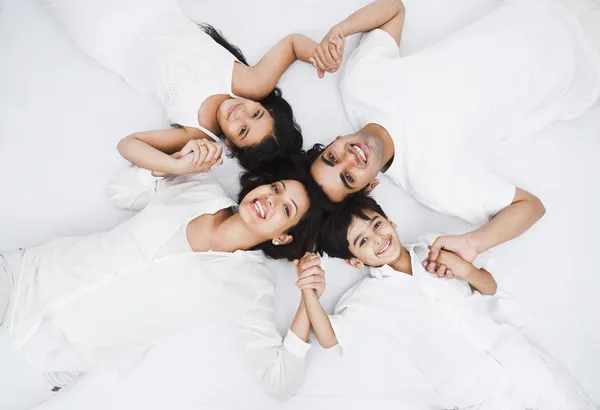 Liggend op het bed en gelukkige familie — Stockfoto