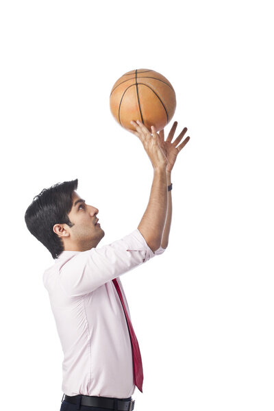 Businessman throwing a basketball