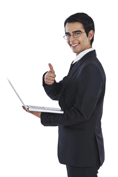 Uomo d'affari utilizzando un computer portatile e mostrando pollici in su — Foto Stock
