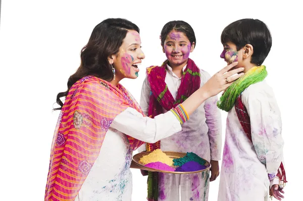 Woman celebrating Holi festival with her children — Stock Photo, Image