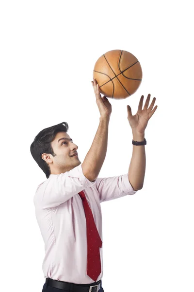 Empresário jogando uma bola de basquete — Fotografia de Stock