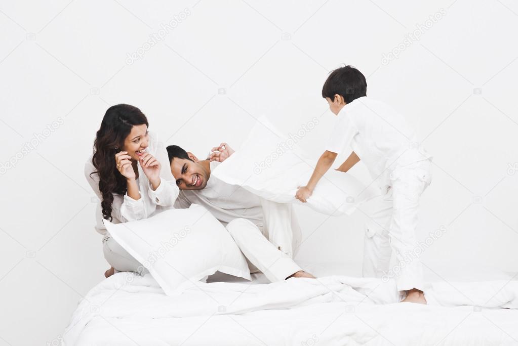Boy pillow fight with his parents