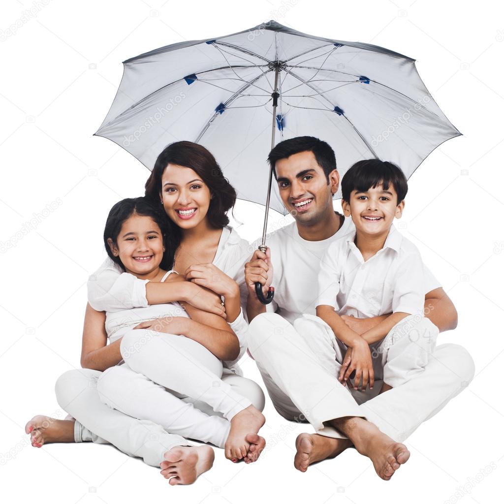 Family sitting under an umbrella