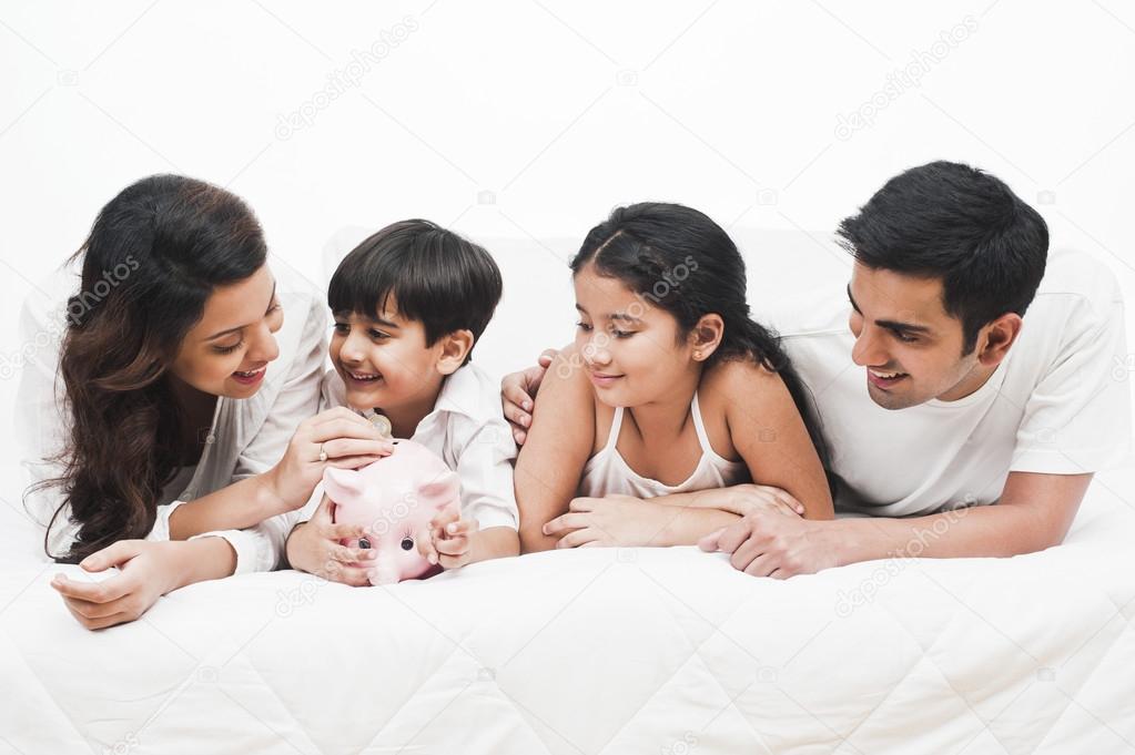 Family with a piggy bank on the bed