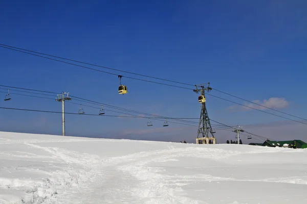 Ski lifts over snow covered landscape — Stock Photo, Image