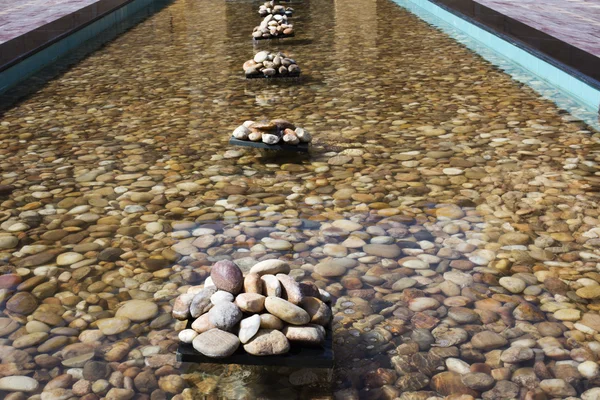 Pebbles in an artificial pond — Stock Photo, Image