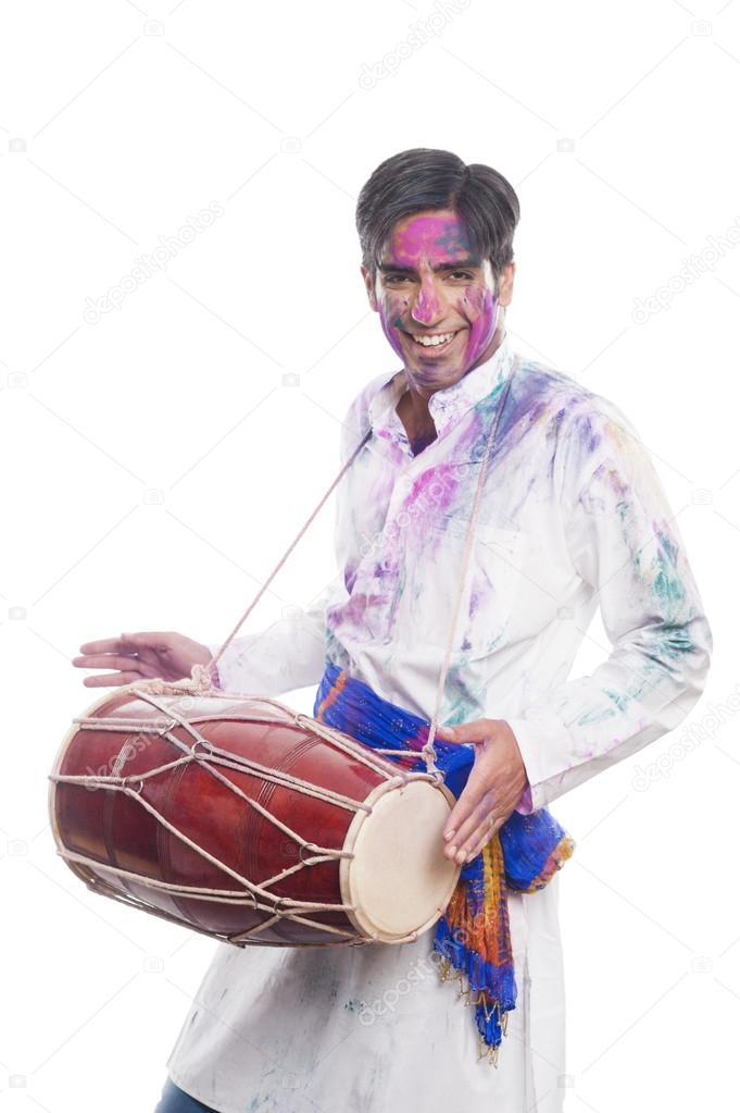 Man celebrating Holi with playing dholak