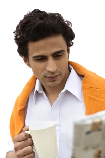 Man holding a coffee mug with reading a newspaper — Stock Photo, Image