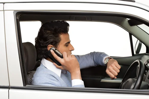 Man sitting in a car and checking the time — Stock Photo, Image