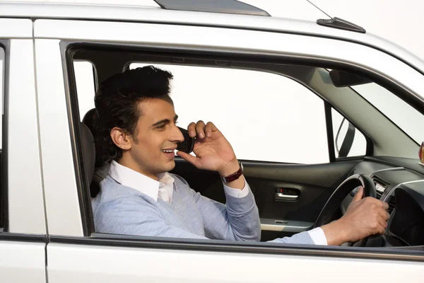 Hombre hablando en un teléfono móvil mientras conduce un coche — Foto de Stock