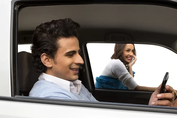 Man sitting in a car with his girlfriend — Stock Photo, Image