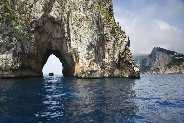 Barca che attraversa un arco naturale — Foto Stock