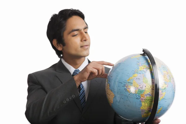 Zakenman kijken naar een globe — Stockfoto