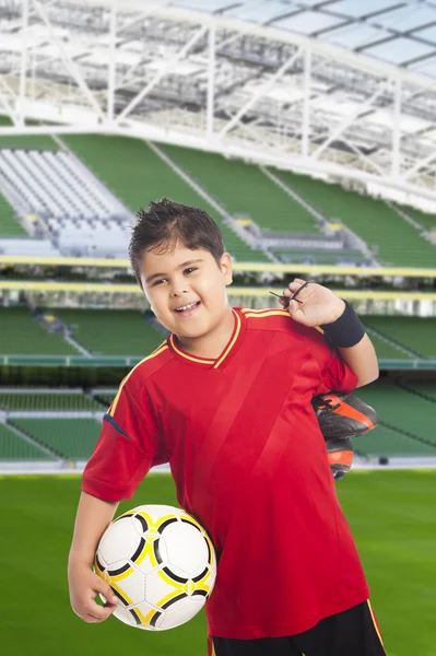 Çocuğun futbol topu ve ayakkabılarını taşıyan — Stok fotoğraf