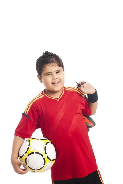 Niño llevando una pelota de fútbol y sus zapatos — Foto de Stock